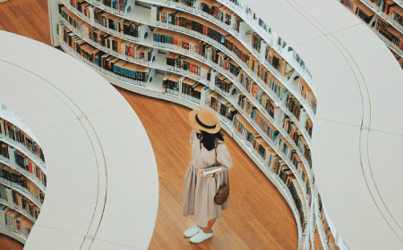 woman hearing a hat and standing in a library